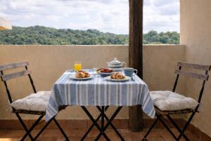 a table with plates of food and drinks on a balcony at Blue Bay Apartment in Cala Bitta