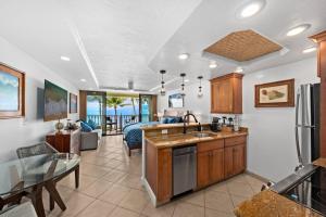 a kitchen and living room with a view of the ocean at Aloha Oceanfront Retreat 327 in Lahaina