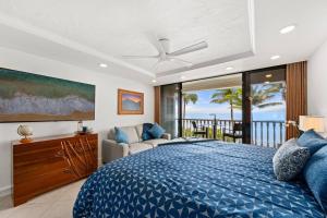 a bedroom with a blue bed and a balcony at Aloha Oceanfront Retreat 327 in Lahaina +67 photos