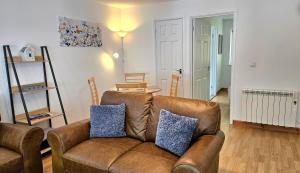 a living room with a brown leather couch at 14 Granite Henge in Looe +24 photos