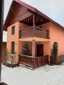 a house with a large balcony with a christmas tree on it at Cabana Violeta Arieseni in Arieşeni