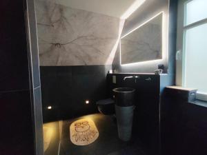 a bathroom with a toilet with a painting on the wall at Haus Auszeitblick in Bad Bentheim +19 photos