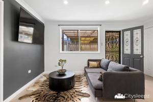 a living room with a couch and a table at Dean Park 2-Bed Unit in Deer Park