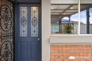 a blue door on a house with a window at Dean Park 2-Bed Unit in Deer Park