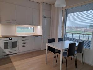 a kitchen with a table and chairs and a window at Spacious Apartment for 4 with Sauna in Oulu