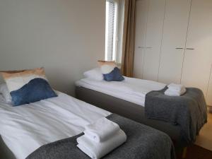 a bedroom with two beds with towels on them at Spacious Apartment for 4 with Sauna in Oulu
