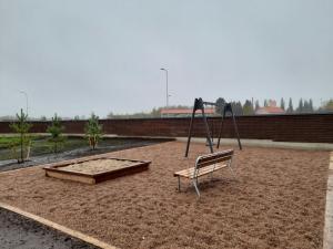 an empty playground with a bench and swings at Spacious Apartment for 4 with Sauna in Oulu