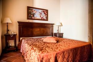 a bedroom with a large bed and two night stands at Feudo Bauly in Palazzolo Acreide