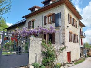 a house with purple flowers on the fence at La chambre du Villard in Saint-Béron