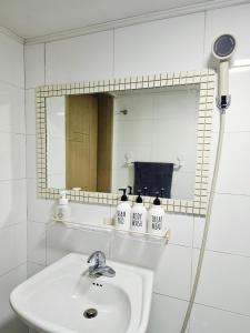 a white bathroom with a sink and a mirror at Stay Onyu in Seoul +18 photos