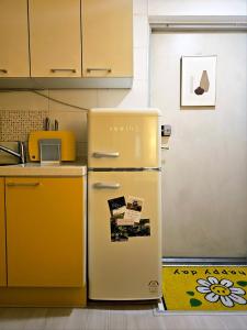 a yellow refrigerator in a kitchen next to a counter at Stay Onyu in Seoul