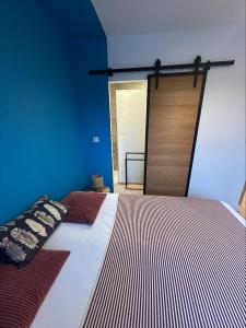 a bedroom with a large bed with a wooden door at L'Opale in Wimereux