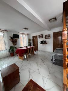 a living room with a table and a bedroom at Cabana Violeta Arieseni in Arieşeni