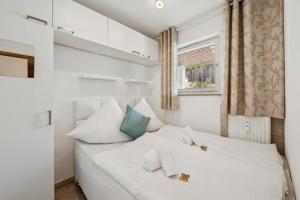 a white bed in a room with a window at Ramoni Apartments - Naturglück in Enzklösterle