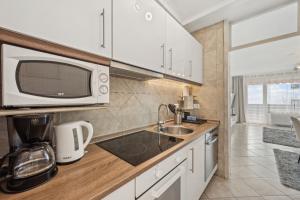 a kitchen with a sink and a microwave at Ramoni Apartments - Naturglück in Enzklösterle