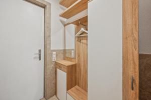 a bathroom with a wooden door and a shower at Ramoni Apartments - Naturglück in Enzklösterle