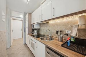 a kitchen with white cabinets and a sink at Ramoni Apartments - Naturglück in Enzklösterle