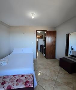 a bedroom with a large bed and a bathroom at Apartamento interino com vista mar in Natal