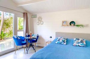 a bedroom with a blue bed and a table at Secret Garden Chalet No. 1 in San Pietro in Bevagna
