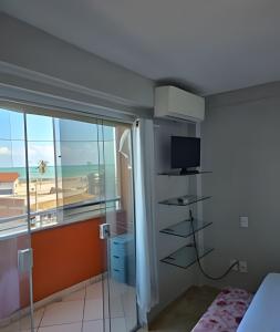 a bedroom with a view of the beach at Apartamento interino com vista mar in Natal