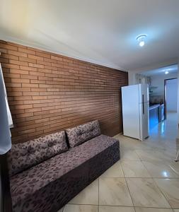 a couch in a room with a brick wall at Apartamento interino com vista mar in Natal