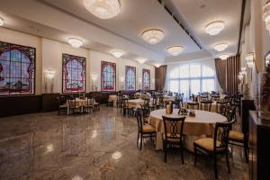 a dining room with tables and chairs and stained glass windows at Hotel Beograd in Čačak