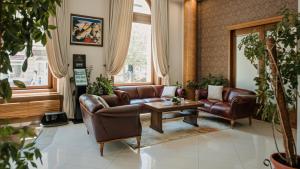 a living room with leather couches and a table at Hotel Beograd in Čačak