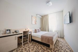 a hotel room with a bed and a desk at Hotel Beograd in Čačak +42 photos