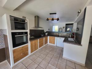 a kitchen with a sink and a stove top oven at Bas de villa moderne avec piscine in Fréjus