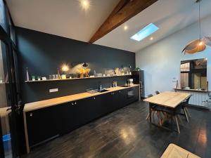 a kitchen with a counter and a wooden table at Loft contemporain in Bordeaux