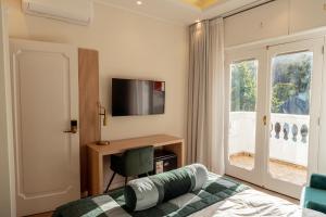 a bedroom with a bed and a tv and a window at Casa D'Agostino in Santiago