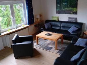 a living room with black couches and a coffee table at Holiday Home Stausee by Interhome in Biersdorf am See