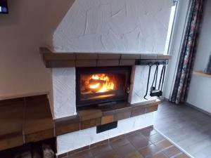 a brick fireplace with a fire in it at Holiday Home Stausee by Interhome in Biersdorf am See
