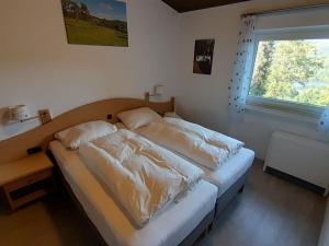 a bedroom with two beds and a window at Holiday Home Stausee by Interhome in Biersdorf am See +24 photos