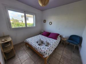 a bedroom with a bed with purple pillows and a window at Bas de villa moderne avec piscine in Fréjus +6 photos