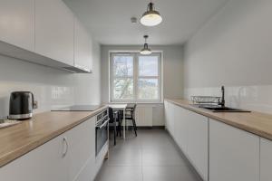 a kitchen with white cabinets and a counter top at So Stay Bed & Breakfast - Self Check-in in Gdańsk