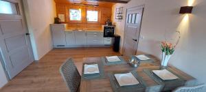 a living room with a table and a kitchen at Landhaus Rickies in Aifersdorf
