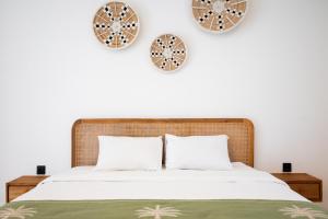a bedroom with a bed with two clocks on the wall at The Aura Inn in Kerobokan