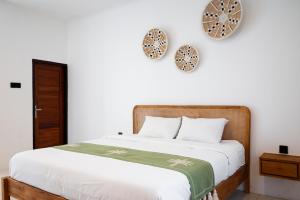 a bedroom with a bed and two clocks on the wall at The Aura Inn in Kerobokan