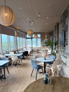 a restaurant with tables and chairs and windows at Housel Bay Hotel in Lizard