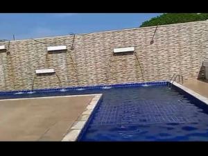 a large swimming pool in front of a brick building at Solares Residence in Teresina