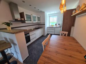 a kitchen with a wooden table and a wooden floor at Apartment Waldstein Terrassen by Interhome in Weißenstadt
