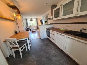 a kitchen with white cabinets and a wooden table at Apartment Waldstein Terrassen by Interhome in Weißenstadt +22 photos