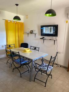 a kitchen with a table and chairs and a tv at Casa en la Punta San luis in La Punta +19 photos