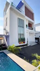 a white house with a swimming pool in front of it at 5bedroom duplex self compound in Lekki