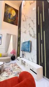 a living room with a couch and a tv on a wall at 5bedroom duplex self compound in Lekki +3 photos