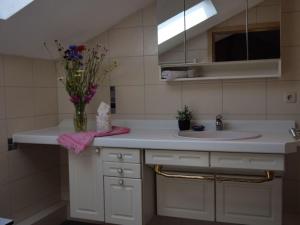a bathroom with a sink and a vase of flowers at Apartment Turmwohnung by Interhome in Kuchelmiß +14 photos