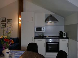 a kitchen with a stove and a microwave at Apartment Turmwohnung by Interhome in Kuchelmiß