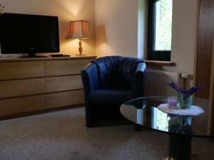 a living room with a chair and a coffee table at Apartment Turmwohnung by Interhome in Kuchelmiß