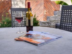 a bottle of wine on a table with a magazine and a glass at Apartment mit Terrasse by Interhome in Mönkebude